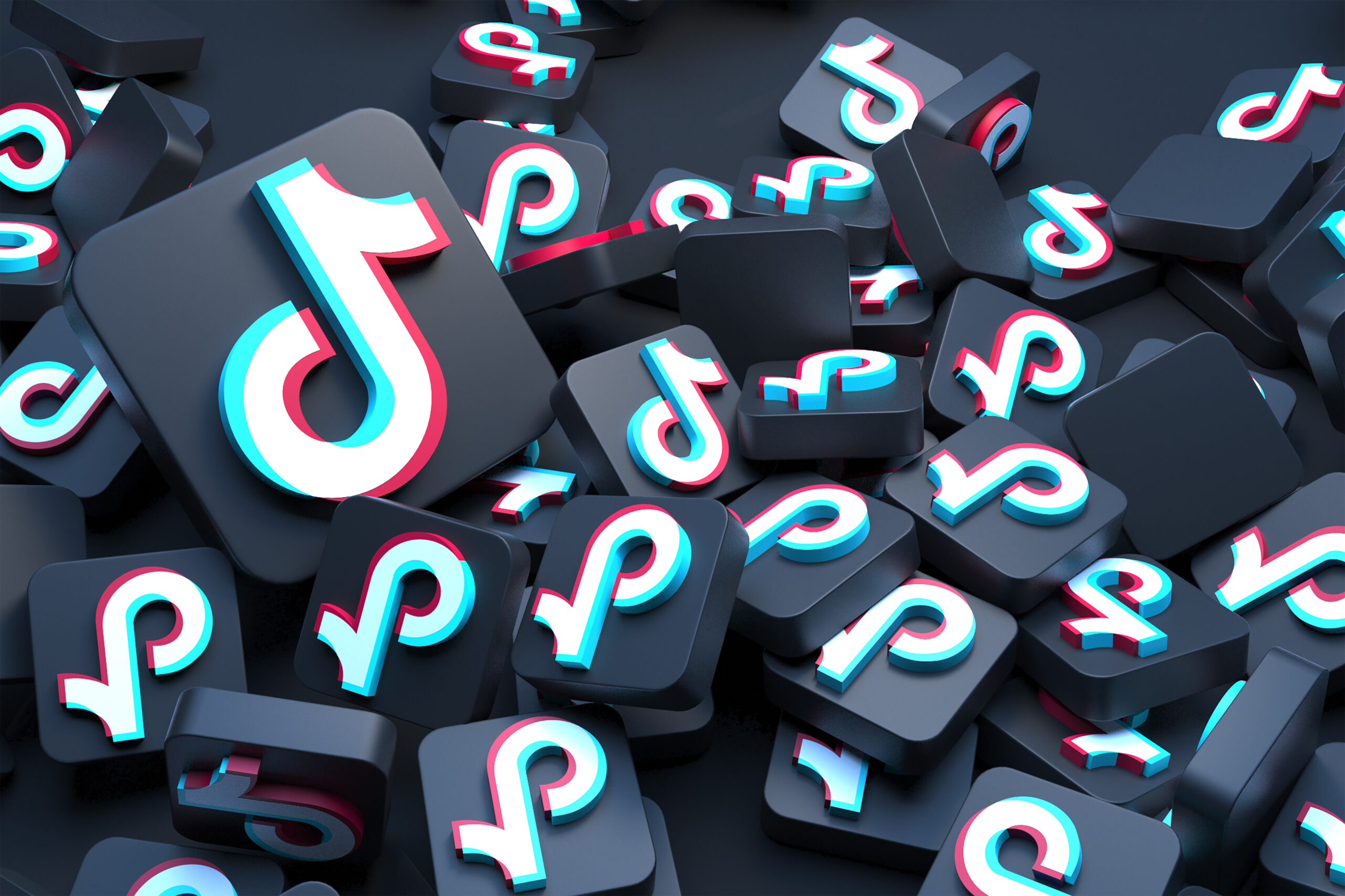 A pile of dark 3D TikTok app icons scattered on top of each other, each showing the TikTok logo in white, cyan, and pink.