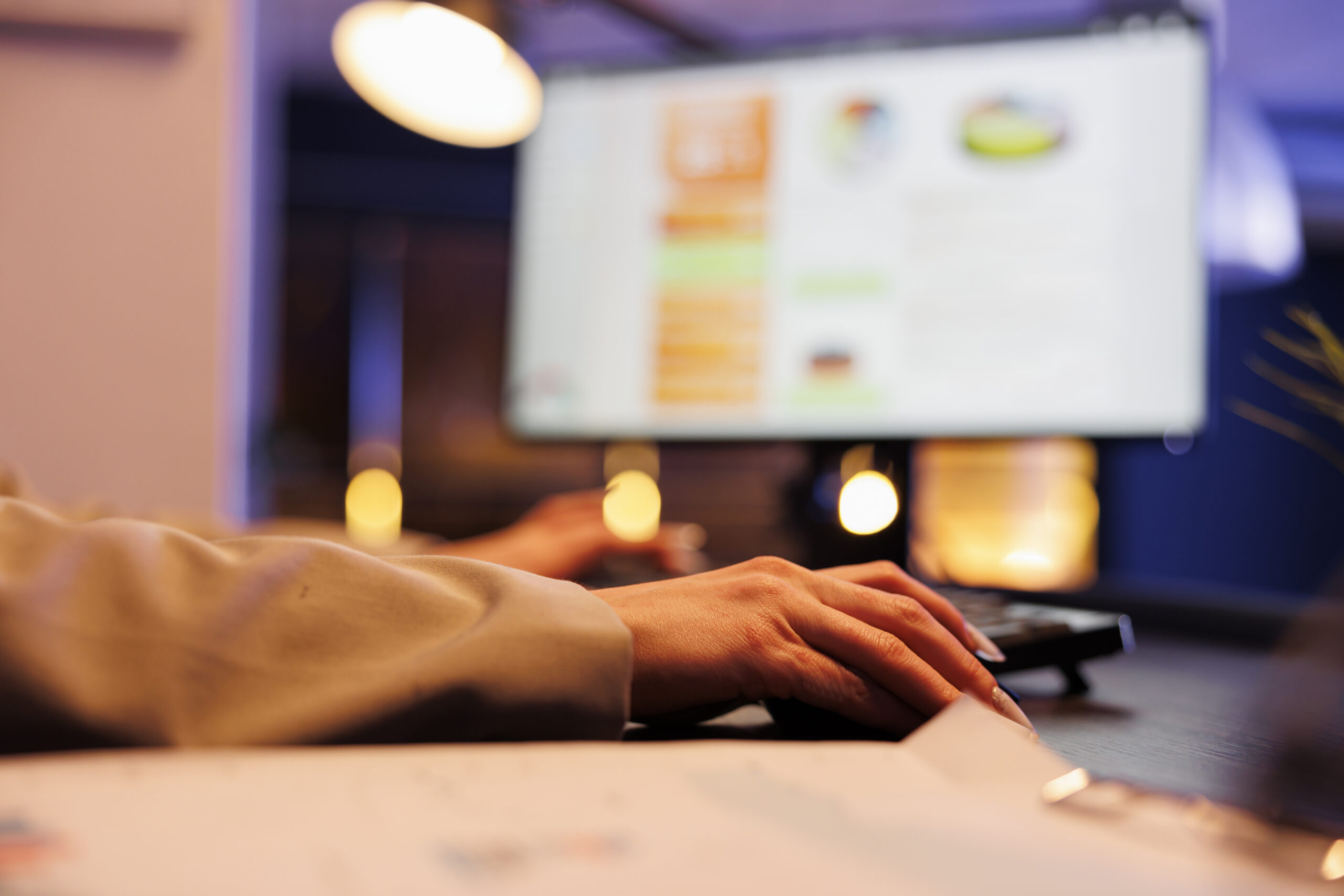 A person working at a desktop computer displaying a colourful UI design interface, representing the difference between UX and UI design.