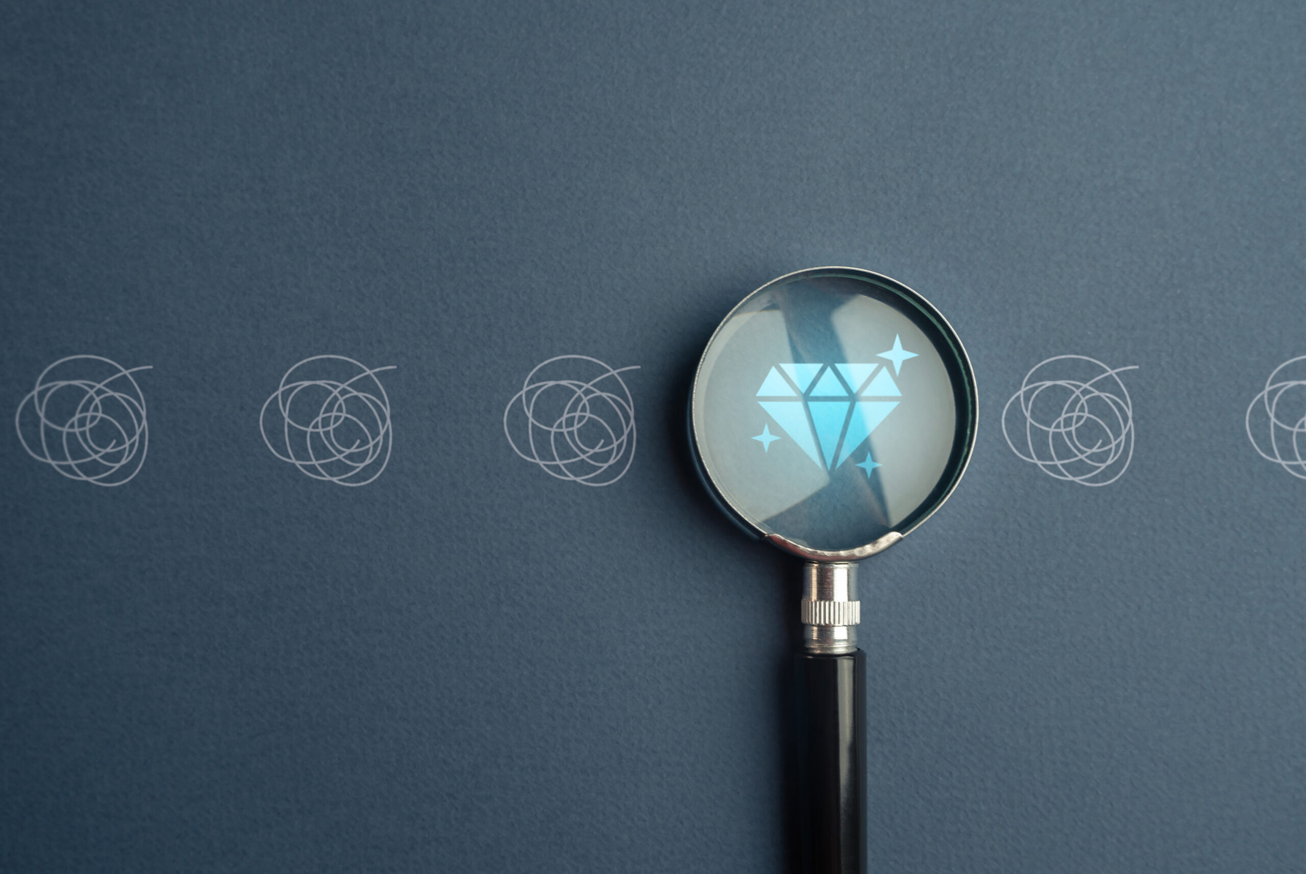 A magnifying glass hovering over a diamond, representing SGE.