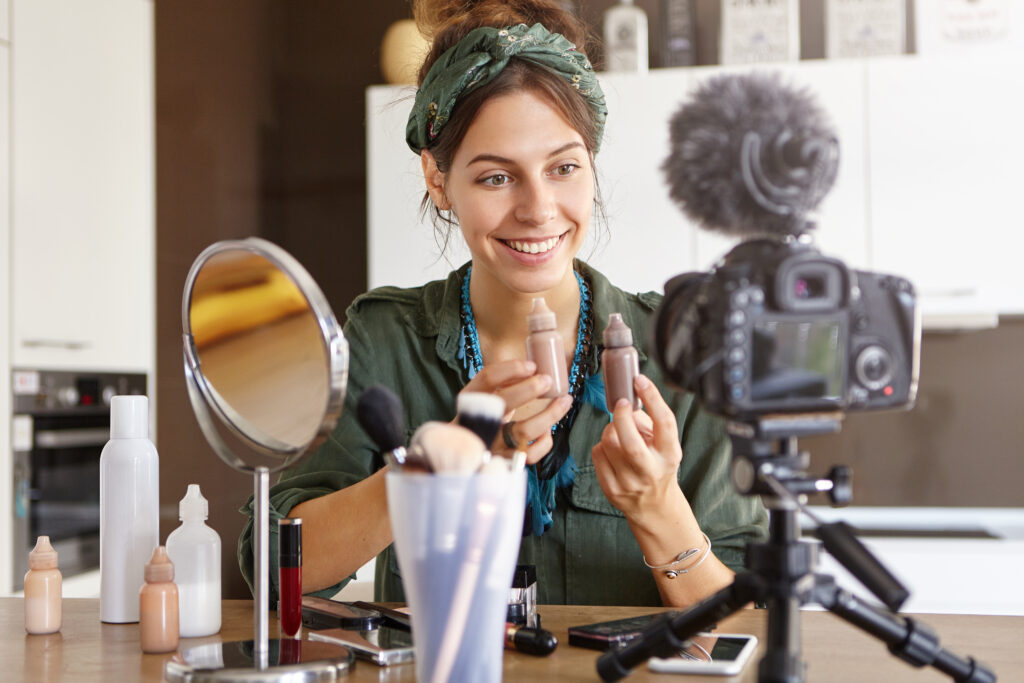 micro influencer presenting beauty cosmetic products sharing with her viewers news while having online translation at home, showing master class on her channel