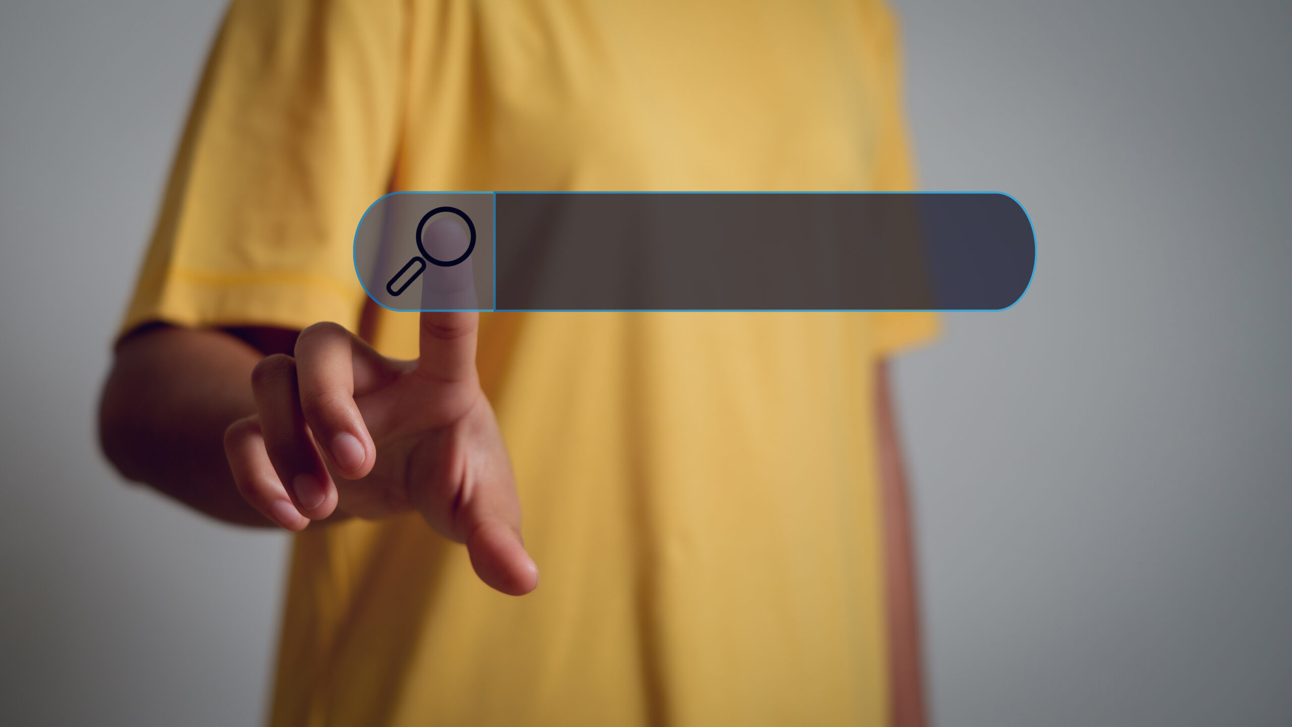 A person in a yellow shirt touching a floating digital search bar icon, representing online search and zero click search.